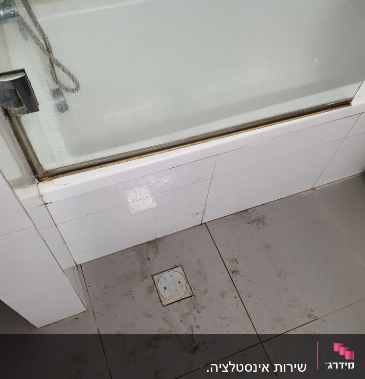 ניקוז רצפה במקלחת עם לכלוך מסביב